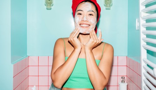 Portrait of beautiful asian woman washing her face in bathroom