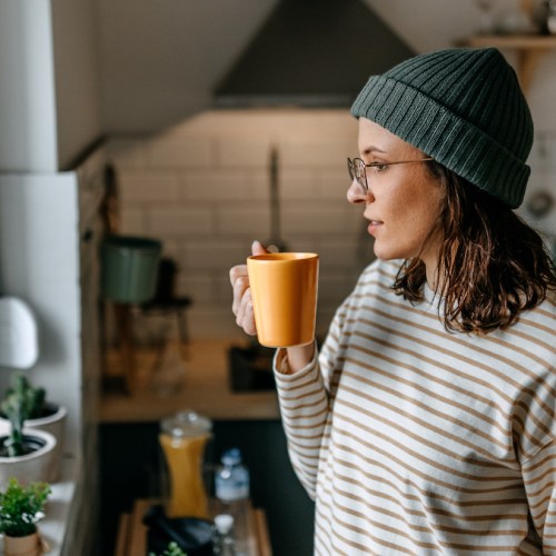 Person holding a cup in the kitchen