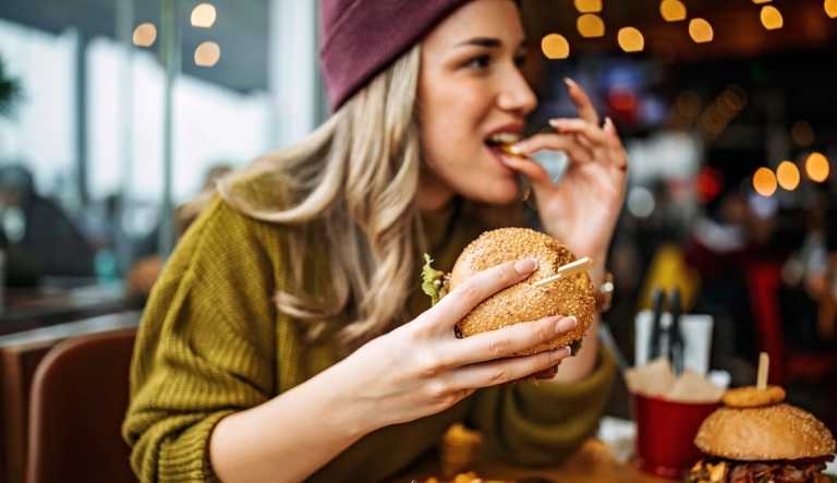 A person eating a burger in a restaurant