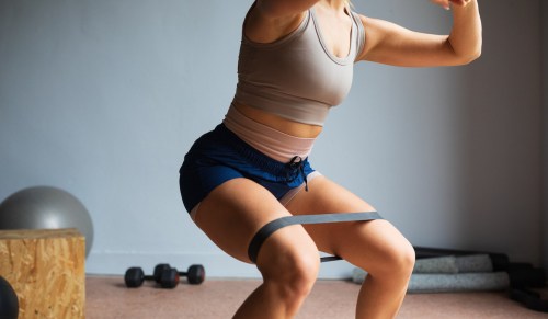 woman doing an upper glutes exercise with an exercise band.