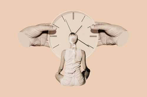 A woman is seen sitting and looking at an oversized clock.