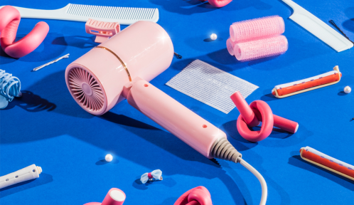 Various scattered hairdresser's tool on blue, including user-friendly hair tools