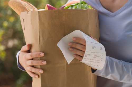 Woman holding grocery bag and receipt