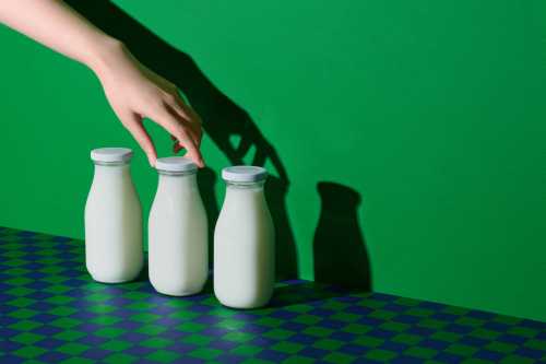 Holding a glass of milk, in the morning, Pure milk drinks in clear jars and bottles are naturally healthy foods