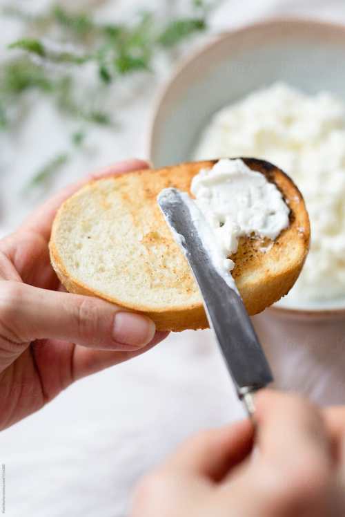 Cottage Cheese on toast with a knife spreading it
