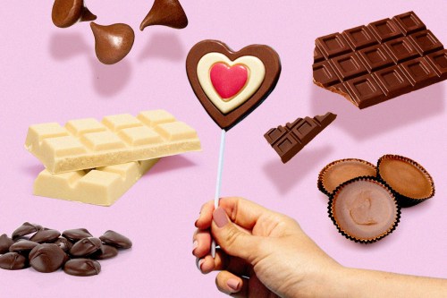 a group of varied chocolates—from bars to truffles—sits on a pink background