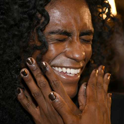 model at fashion week with short gold nails