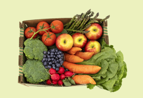 an overhead shot of a box of fresh produce on a green surface