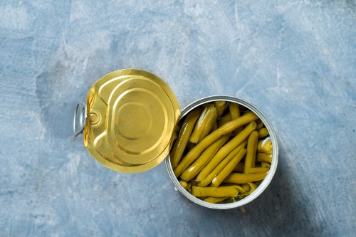 a can of green beans opened on a blue surface