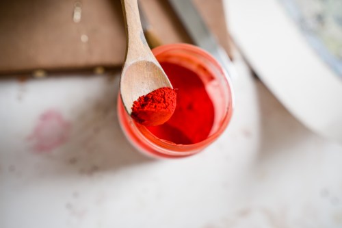 red pigment in a wooden spoon