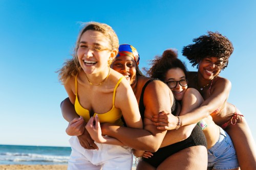 women on beach with summer essentials