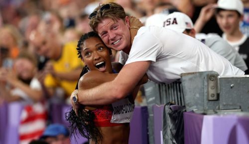 Tara Davis-Woodhall of Team United States celebrates with husband Hunter Woodhall after winning the gold medal in the Women's Long Jump Final on day thirteen of the Olympic Games Paris 2024 at Stade de France on August 08, 2024 in Paris, France.