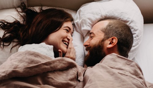 Two people in a couple gaze into each other's eyes after trying the reverse cowgirl position.