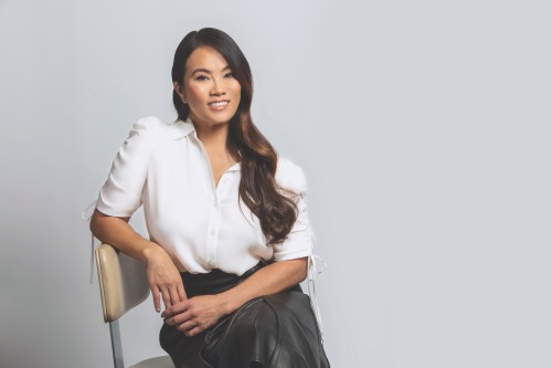 Dr. Sandra Lee, also known as Dr. Pimple Popper online, sitting and posing for a photo