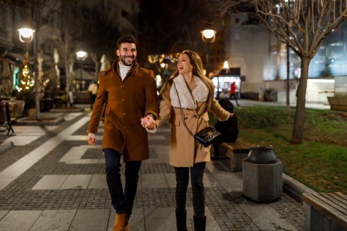 A Man and his Girlfriend Walking in the Street During a Cold Night, Exploring the City and Enjoying the Time Together.