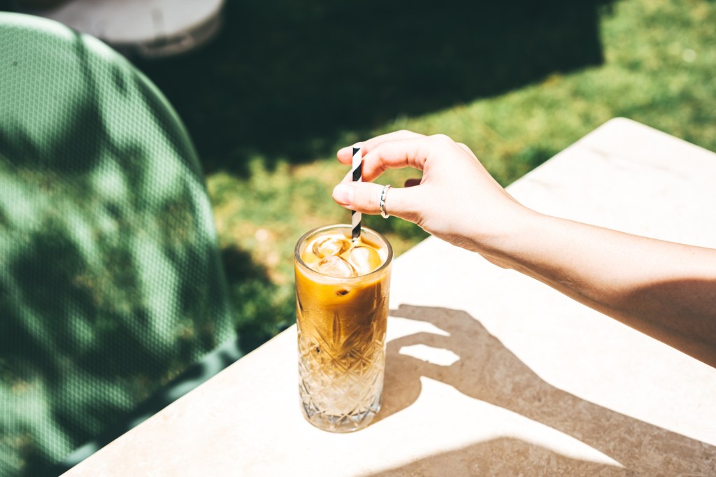 Person swirling their iced coffee with a straw