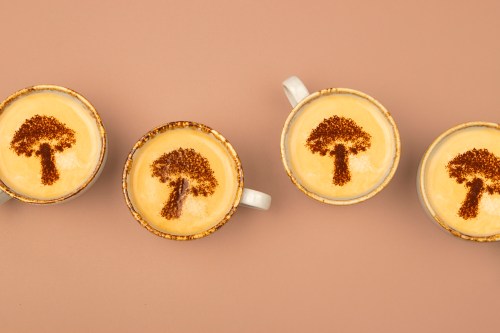 Directly above shot of coffee cups with latte art on brown background