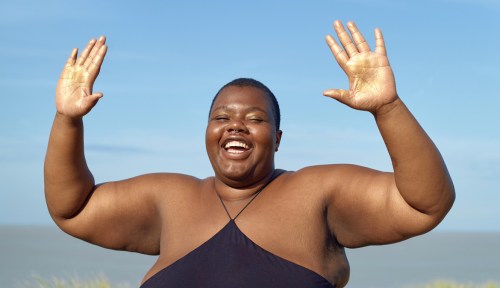 A person celebrates the sunshine in the weekly horoscope for May 11 to 17, 2025.
