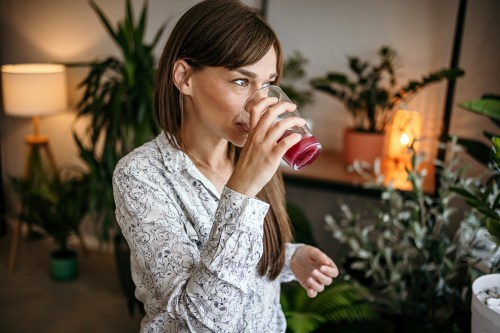close up of person drinking juice in hopes that it will be a natural cancer treatment alternative