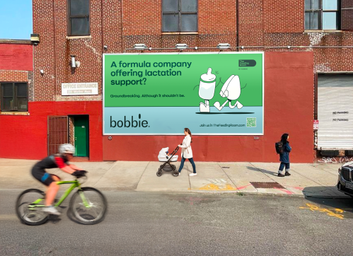 street image of people walking past the new Bobbie formula lactation support service billboard in Williamsburg, New York City